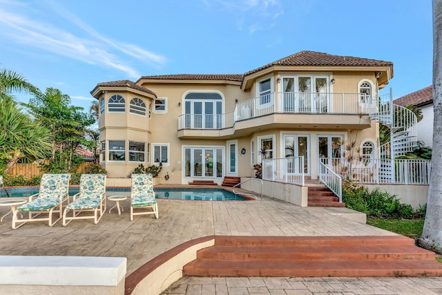 back of house with a balcony, a patio, and french doors