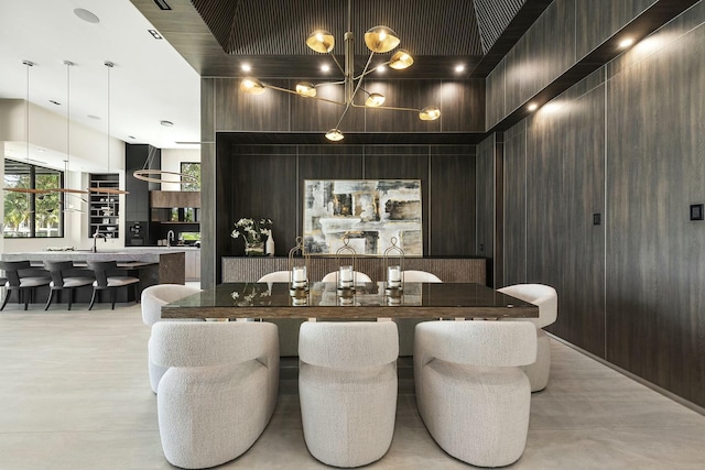 dining room featuring wooden walls and a chandelier