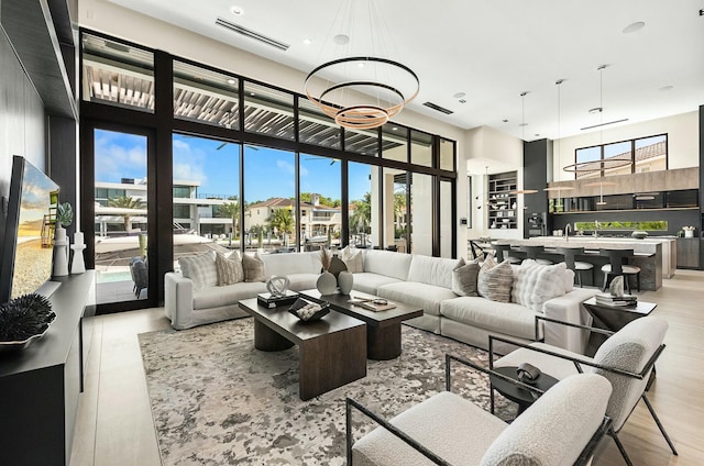 living room with a notable chandelier, a healthy amount of sunlight, and a high ceiling