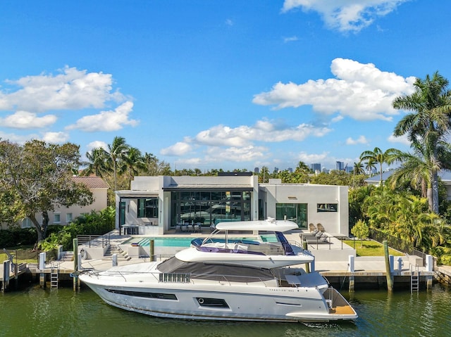 dock area with a water view, a community pool, and a patio area