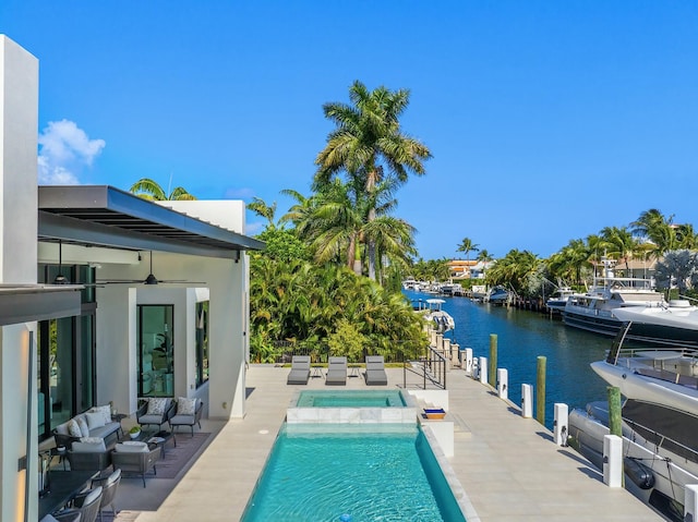 view of swimming pool with a patio, an outdoor hangout area, a water view, an in ground hot tub, and ceiling fan