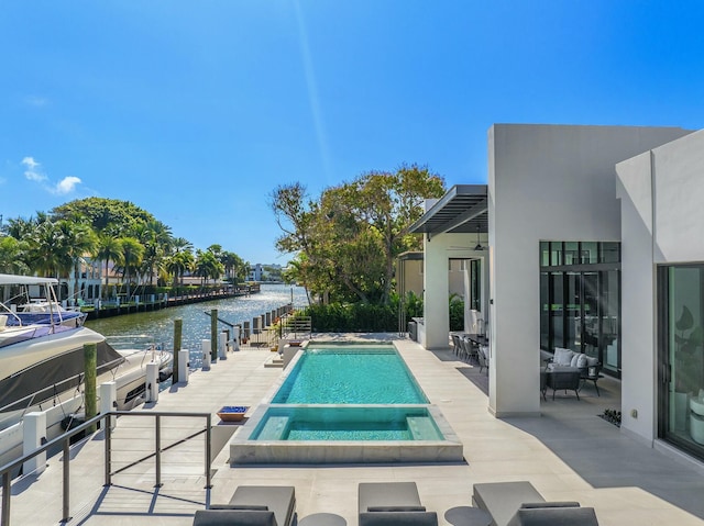 view of swimming pool with an in ground hot tub, a water view, a patio area, and ceiling fan