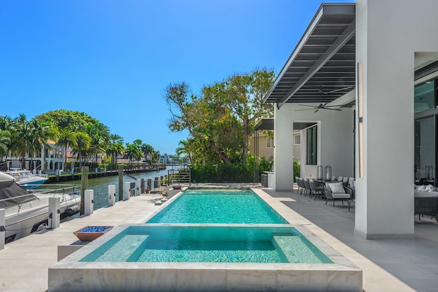 view of swimming pool featuring a patio area, a water view, ceiling fan, and an in ground hot tub