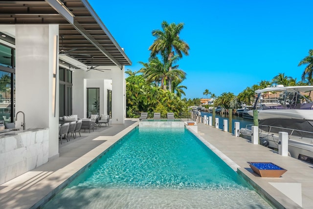 view of pool featuring a patio, a water view, outdoor lounge area, and ceiling fan