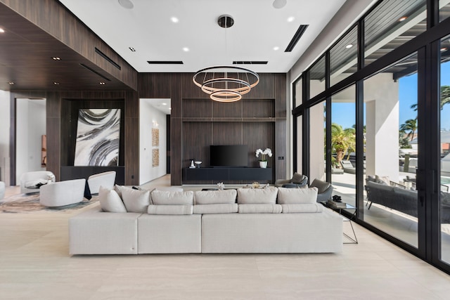 living room featuring an inviting chandelier and wood walls