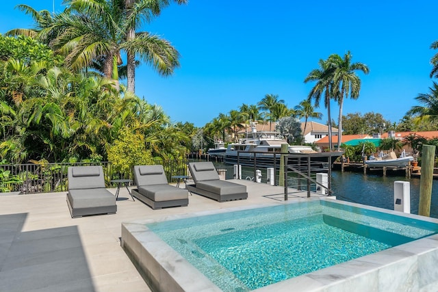 view of swimming pool featuring a patio and a water view