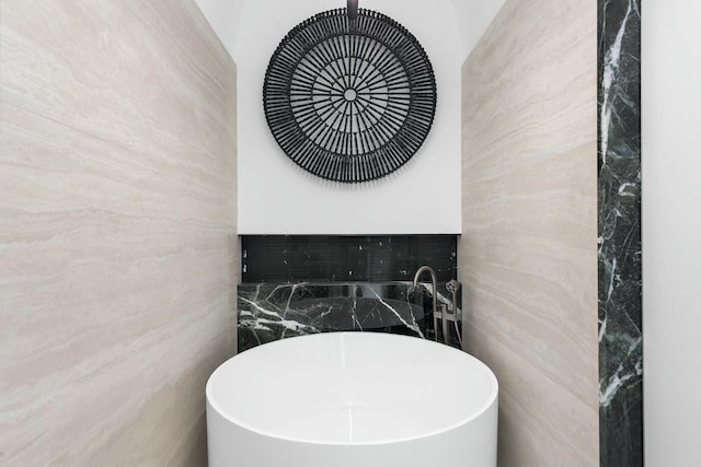 bathroom featuring tile walls and a bathing tub