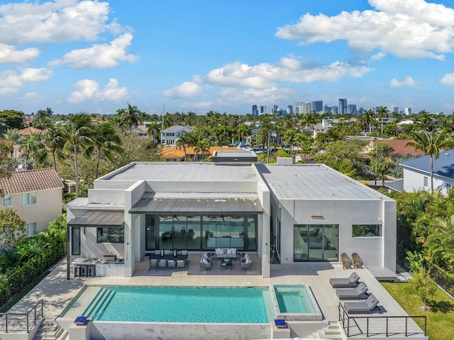 back of property featuring a swimming pool with hot tub, an outdoor hangout area, and a patio area