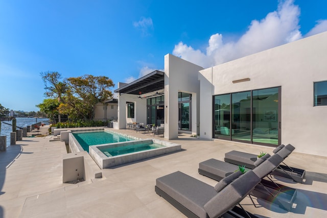 view of pool featuring a patio, an in ground hot tub, and a water view