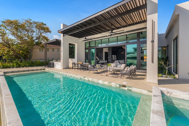 view of pool featuring ceiling fan, a patio area, and an outdoor living space