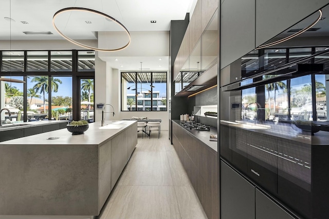 kitchen featuring sink, a large island, oven, and stainless steel gas stovetop