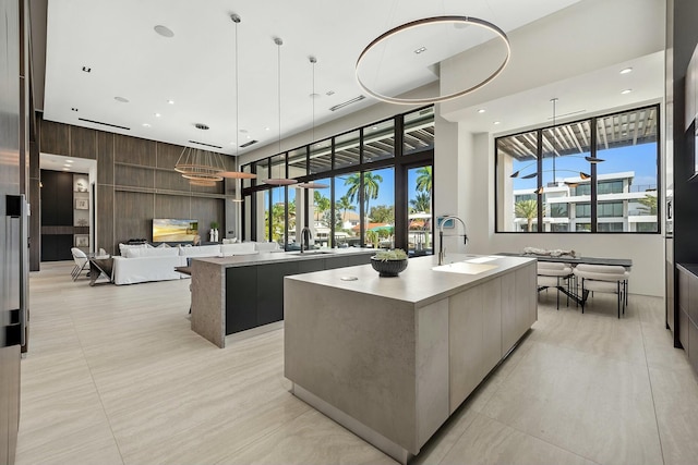 kitchen featuring plenty of natural light, sink, pendant lighting, and a kitchen island with sink