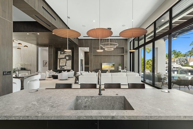 kitchen featuring sink, hanging light fixtures, and a high ceiling