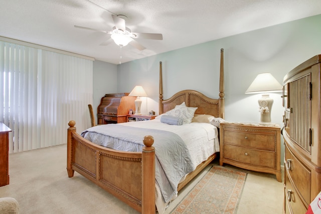 bedroom featuring a textured ceiling, light colored carpet, and ceiling fan