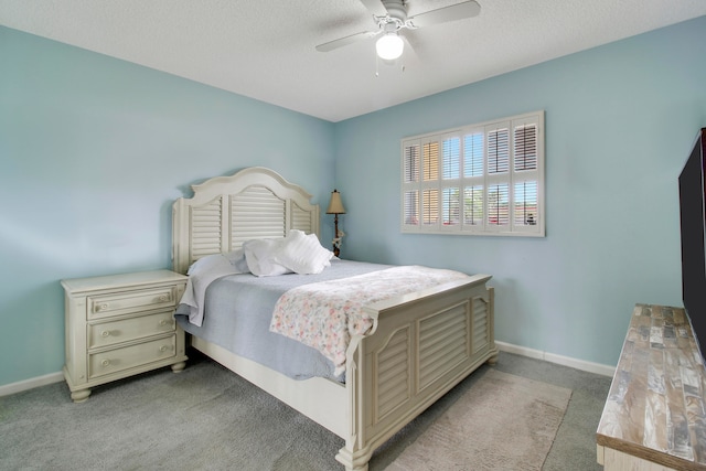 carpeted bedroom with ceiling fan and a textured ceiling