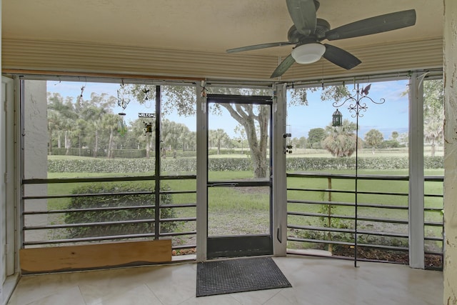 unfurnished sunroom with ceiling fan