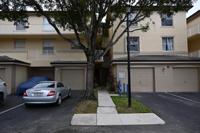 view of property with a balcony and a garage