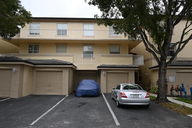 townhome / multi-family property featuring a balcony and a garage