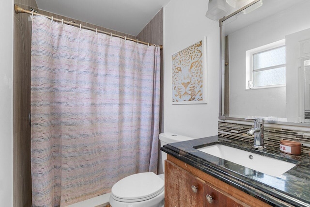 bathroom with vanity, toilet, and tasteful backsplash