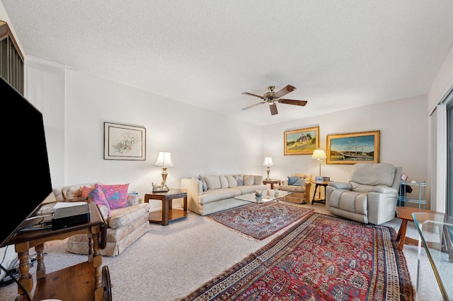 living room featuring ceiling fan, a textured ceiling, and carpet floors