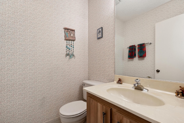 bathroom with vanity, a textured ceiling, and toilet