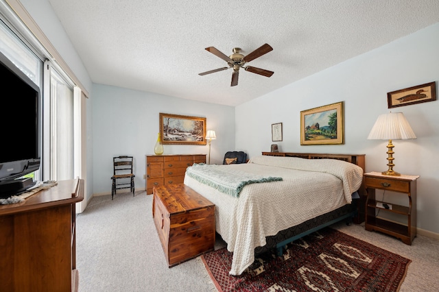 bedroom with ceiling fan, a textured ceiling, and light carpet