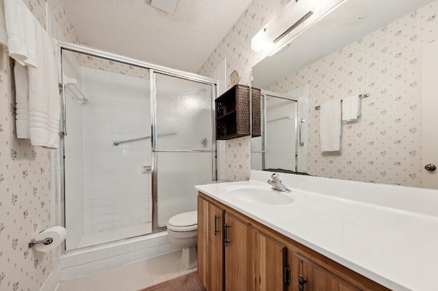 bathroom with tile patterned floors, vanity, a textured ceiling, an enclosed shower, and toilet