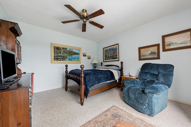 bedroom featuring a textured ceiling, light colored carpet, and ceiling fan