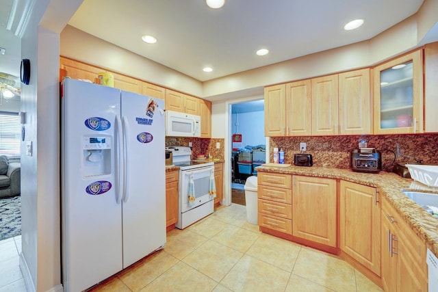 kitchen with decorative backsplash, light brown cabinets, and white appliances