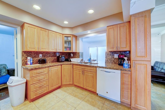 kitchen featuring dishwasher, tasteful backsplash, light stone countertops, and sink