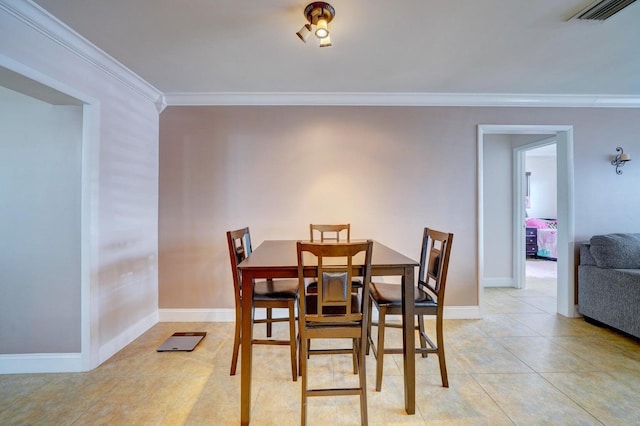 dining area with light tile patterned floors and crown molding