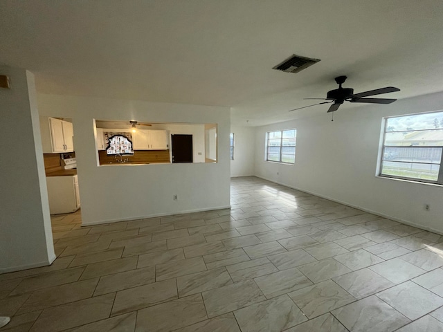 unfurnished living room featuring plenty of natural light and ceiling fan