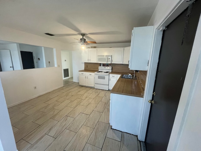 kitchen with light hardwood / wood-style floors, white cabinets, sink, ceiling fan, and white appliances