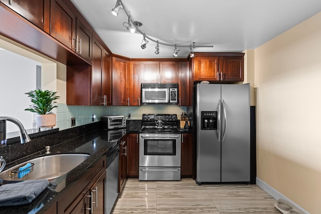 kitchen with decorative backsplash, sink, dark stone counters, and appliances with stainless steel finishes