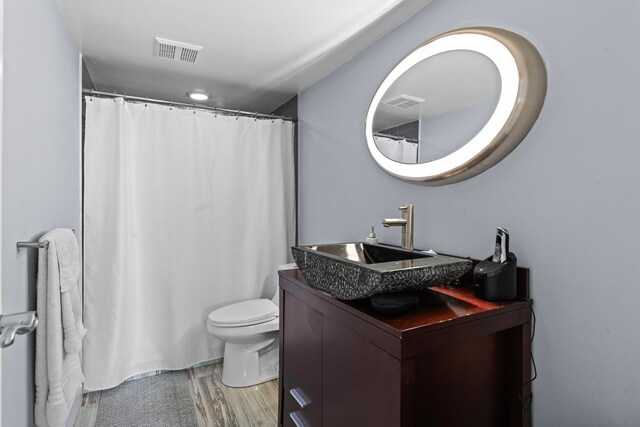 bathroom featuring vanity, hardwood / wood-style flooring, and toilet