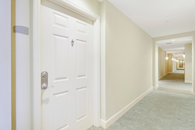 hallway featuring light colored carpet