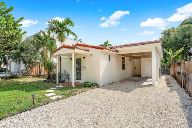 back of property with a yard and a carport