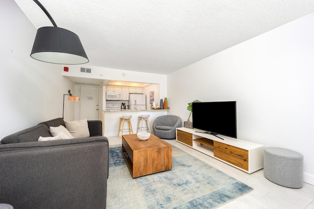 tiled living room with a textured ceiling