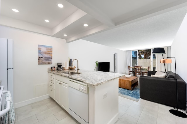 kitchen with kitchen peninsula, white appliances, sink, and light stone countertops