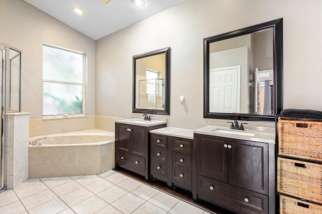 bathroom featuring lofted ceiling, a textured ceiling, tile patterned floors, and vanity