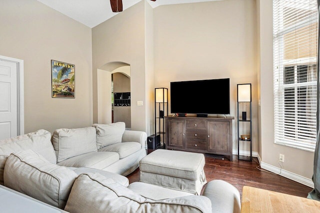 living room featuring ceiling fan, high vaulted ceiling, and dark hardwood / wood-style flooring