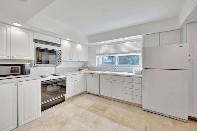 kitchen with white cabinetry, light tile patterned flooring, white appliances, and sink