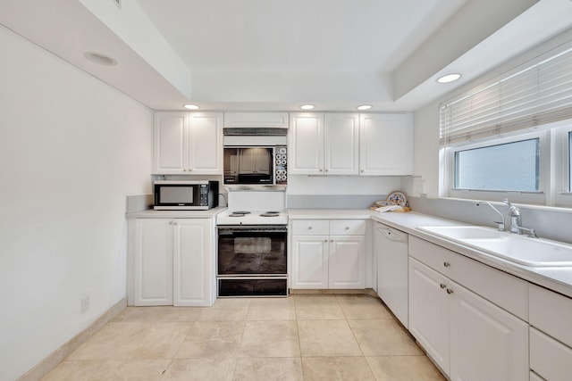 kitchen featuring white cabinets, light tile patterned flooring, white appliances, and sink