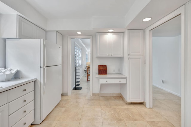 kitchen with white cabinets, light tile patterned floors, and white refrigerator