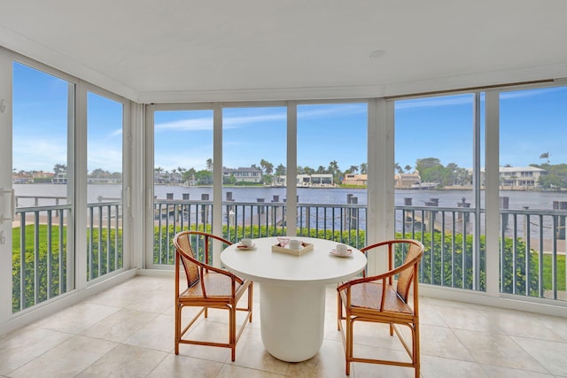 sunroom / solarium featuring a water view and a healthy amount of sunlight