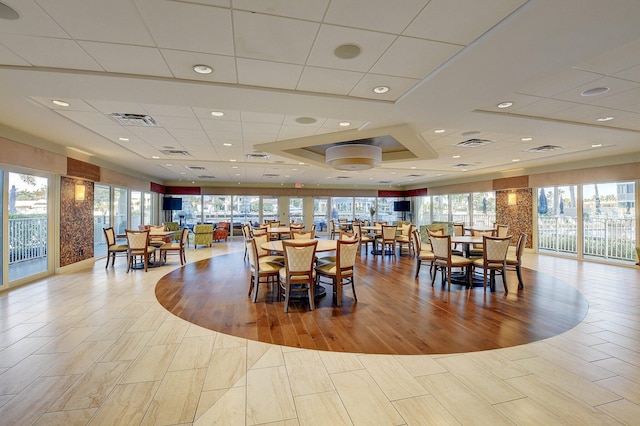 dining room with light hardwood / wood-style flooring and a drop ceiling