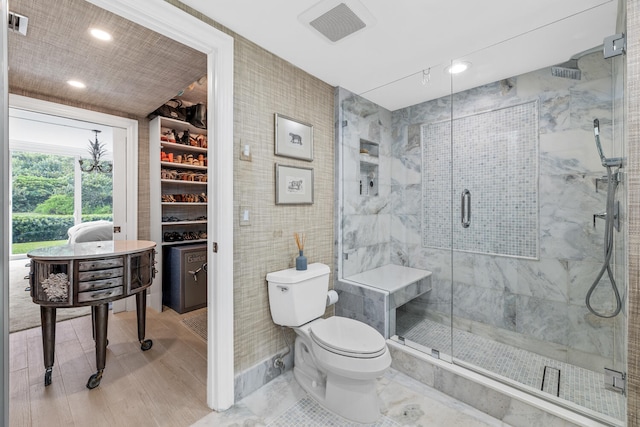 bathroom featuring tile walls, toilet, and a shower with door