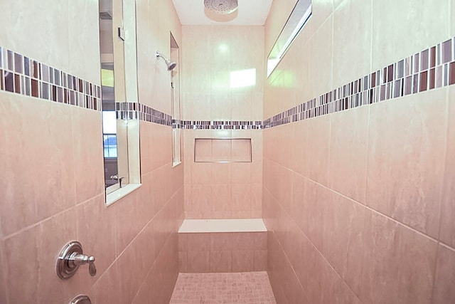 bathroom with a healthy amount of sunlight and tile walls