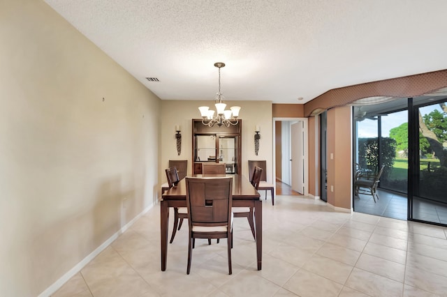 dining area with a notable chandelier, light tile patterned flooring, and a textured ceiling