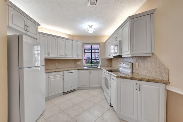 kitchen featuring white cabinetry, white appliances, and tasteful backsplash